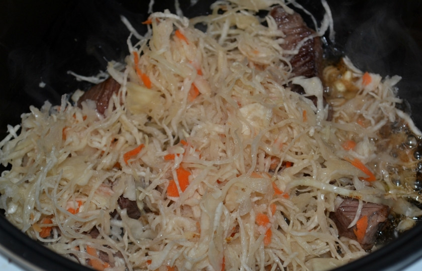 1. Этап. Тушеная квашеная капуста в мультиварке: 6. Введите капусту, предварительно отжав её от жидкости. Перемешайте и готовьте несколько минут.