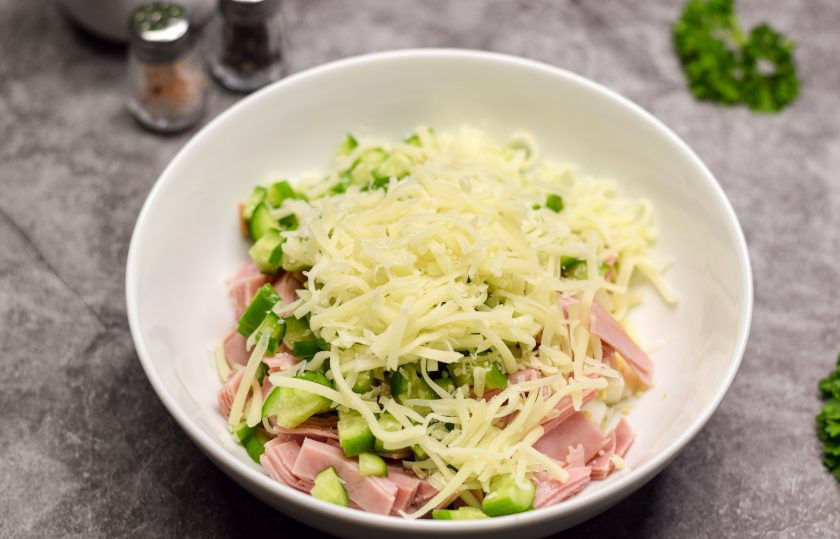 1. Этап. Салат Фантазия с яйцами и сыром: Твердый сыр натрите на средней или мелкой терке, добавьте в салат.