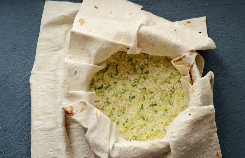 1. Этап. Пирог из лаваша с кабачками: В форму для выпечки выложите один слой лаваша. Смажьте растительным маслом. Выложите ещё один слой лаваша поперёк. В центр переложите начинку.