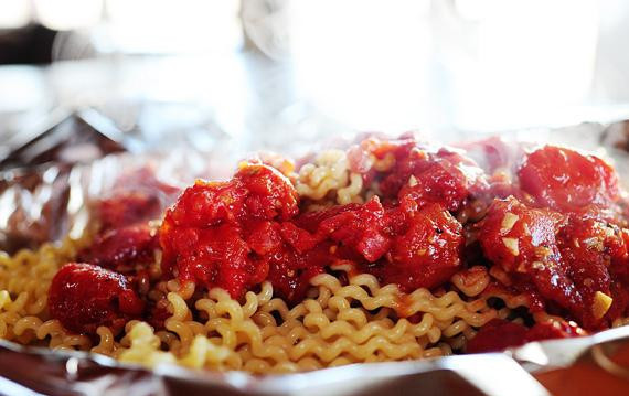 1. Этап. Паста с морепродуктами и помидорами: 5. Выстелить форму для выпечки двумя листами фольги, создавая по краям навес около 15 см. Выложить пасту в форму и залить приготовленным соусом.