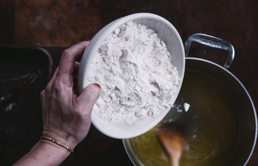 1. Этап. Пончики из заварного теста: 2. В кастрюльку отправьте воду, сливочное масло и соль. Доведите до кипения и всыпьте дважды просеянную муку.