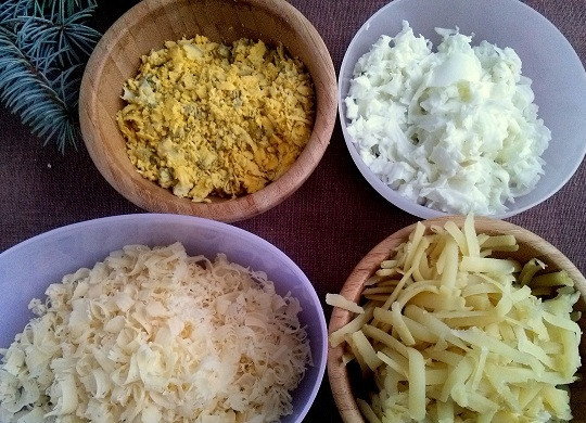 1. Этап. Салат Метелица: Отварные картофель и яйца остудите и очистите. Желток отделите от белка. Картофель натрите на крупной терке, желток, белок и сыр — на мелкой.