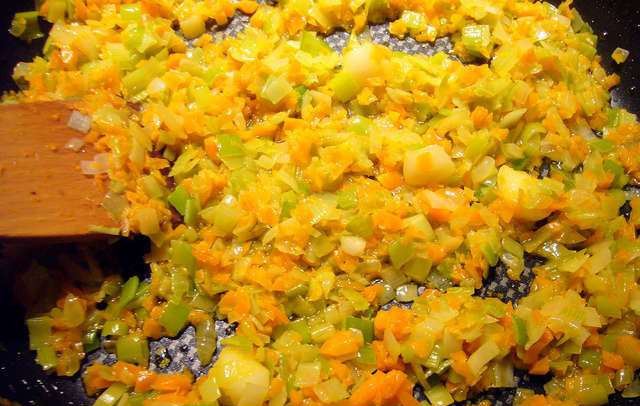 1. Этап. Ризотто с овощами и грибами: Растопите на сковороде 60 грамм сливочного масла. Обжарьте лук репчатый и порей до прозрачности, примерно 7 минут. Добавьте морковь и раздавленный зубчик чеснока. Тушите еще 5 минут. В конце - выбрасываем чеснок.