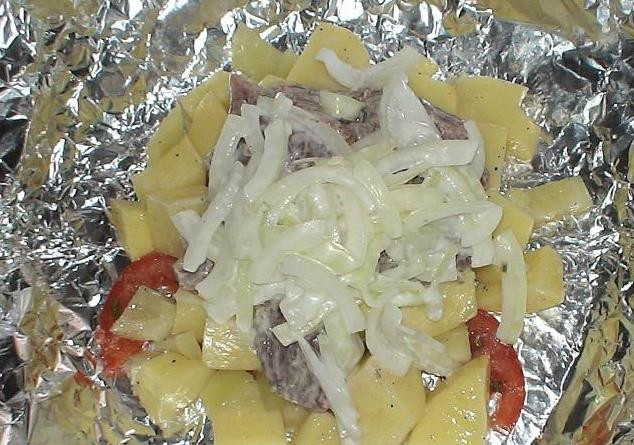 1. Этап. Говядина в фольге с овощами: Берем прямоугольный кусок фольги. В центр выкладываем помидоры, сверху перец, картофель, затем мясо и лук (его отожмем от маринада и немного добавим майонеза).