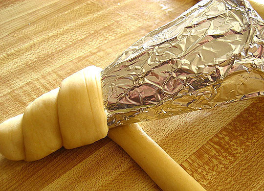 1. Этап. Пицца в рожке: 1. Чтобы все сделать правильно, используйте конус из бумаги или картона. Обматаем его фольгой, а затем - подготовленным тестом по кругу. Пока тесто мягкое, посыпьте его солью и специями, если хотите.