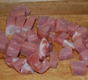 1. Этап. Гречка по-деревенски: Свинину промойте и нарежьте небольшими кубиками. Лук порежьте полукольцами.