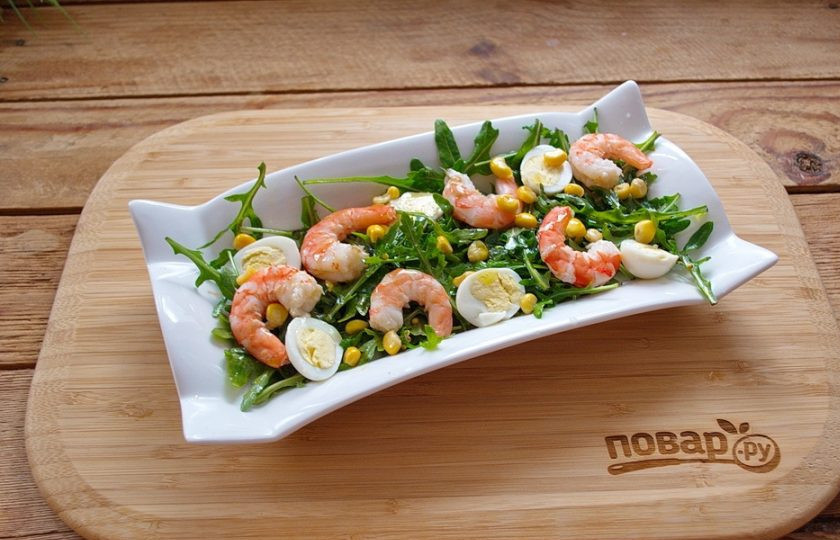 1. Этап. Салат с креветками и рукколой: Креветки в продаже бывают вареные или сырые. Вареные для надежности ошпарьте кипятком и очистите, удалив панцирь и хвостики. Сырые креветки отварите в соленой воде (несколько минут). Очищенные креветки выложите на салат, сбрызнув растительным маслом.