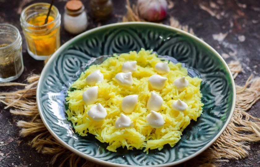 1. Этап. Салат из печени трески слоеный: Картофель натрите на мелкой терке, выложите в салат первым слоем, посолите немного и смажьте майонезом.