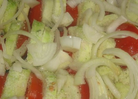 1. Этап. Кабачки с манкой: Теперь выкладываем кабачки на смазанный маслом противень, смешивая с порезанными помидорами и луком.