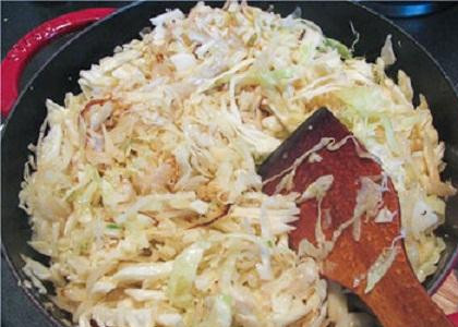 1. Этап. Капустная запеканка с творогом: 2. Подготовить овощи. Лук нарезать полукольцами, чеснок мелко нарезать. Нашинковать тоненько капусту. В сковородке растопить сливочное масло и обжарить на нем лук и чеснок. Добавить в лук капусту. Положить соль, перец и тмин с семенами укропа. Перемешать и жарить, пока капуста не станет красивого золотистого цвета.