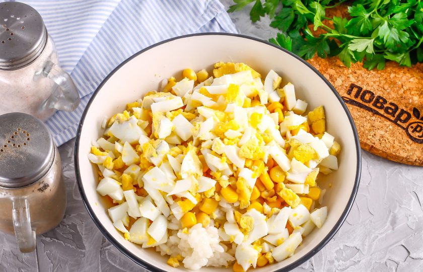 1. Этап. Салат с копченой курицей и рисом: Очистите куриные яйца от скорлупы, промойте в воде и нарежьте кубиками, добавьте к остальным ингредиентам.
