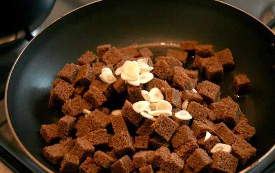 1. Этап. Салат из кукурузы и сухариков: 1. Черный хлеб у меня вчерашний, нарезаю его небольшими кубиками и обжариваю на сковороде с добавлением растительного масла. Очищаю и нарезаю чеснок тонкими пластинками, добавляю в самом конце к сухарикам.