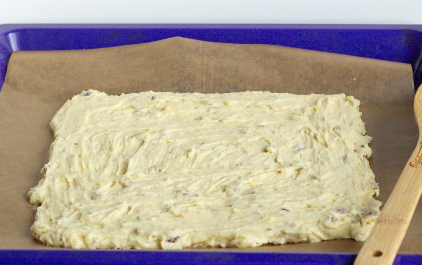 1. Этап. Пирожные с орехами пекан: Выложите тесто на противень, застеленный пекарской бумагой. Толщина теста должна быть 1-1,5 см. Т. к. тесто немного расползется во время выпечки, оставьте место по краям. Выпекайте 20-25 минут при температуре 180 градусов.