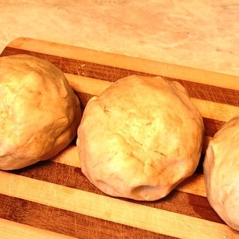 1. Этап. Пирожное с варёной сгущёнкой: Хорошенько смешав все ингредиенты, кладем смесь на присыпанную мукой рабочую поверхность и месим тесто. Получившееся тесто делим на 3 равные части, каждую из которых скатываем в шарик. Ставим наши шарики в морозилку на 20-25 минут.