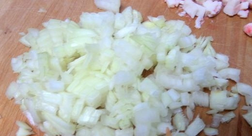 1. Этап. Блины с крабовым припеком: Репчатый лук очистите от шелухи, вымойте и обсушите бумажными полотенцами. Затем нарежьте его мелкими кубиками при помощи острого ножа, соедините лук с крабовыми палочками.