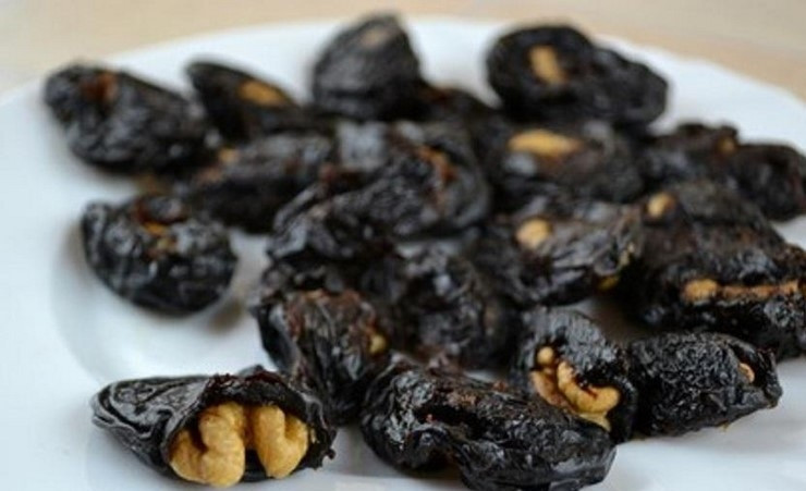 1. Этап. Чернослив с орехами в сметане: 2. Тем временем чищу грецкие орехи и каждое ядро разделяю на четыре части. Сливаю воду с распаренного чернослива, выкладываю его на полотенце бумажное, остужаю и обтираю. В каждом отрезаю небольшой кусочек, делая как бы карманчик, внутрь каждого кладу орешек.