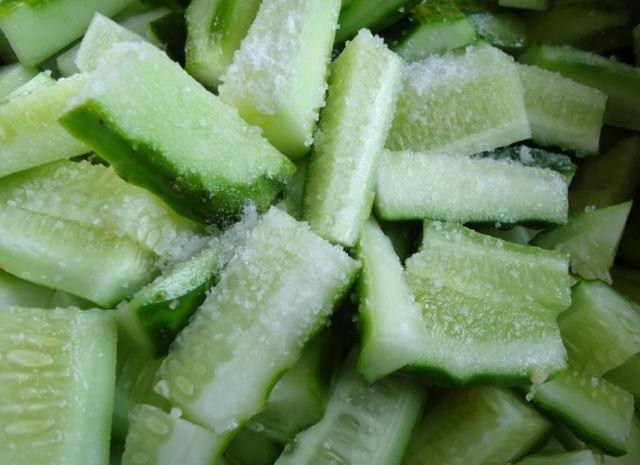 1. Этап. Огурцы по-корейски: Кладем в достаточно глубокую посуду, засыпаем солью, перемешиваем и оставляем на минут 20, чтоб огурцы пустили сок.