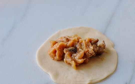 1. Этап. Жаренные китайские пельмени: Тесто раскатайте толщиной в 0,5 см, с помощью стакана вырежьте кружочки диаметром 9-10 см. Выложите сверху начинку.