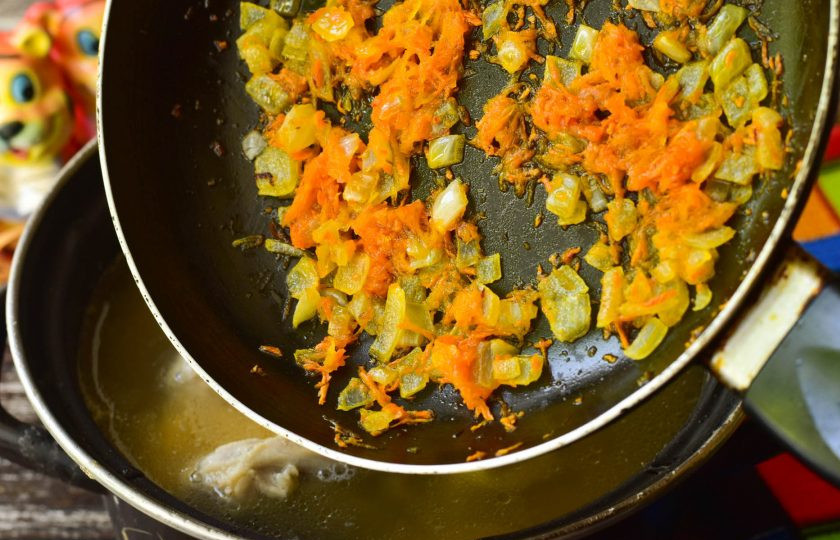 1. Этап. Гороховый суп с лапшой: В сковороде нагрейте растительное масло, выложите измельченный лук и морковь. Обжарьте овощи, а затем выложите полученную зажарку в суп. Варите суп еще 5-7 минут.