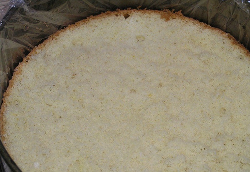 1. Этап. Торт Малиновая роскошь: Застелите разъемную форму для торта пищевой пленкой, на дно выложите бисквитный корж.