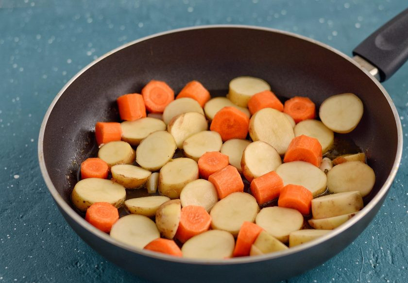 1. Этап. Глазированные овощи: Переложите в сковороду картошку и морковь. Налейте воды так, чтобы она только покрывала овощи.