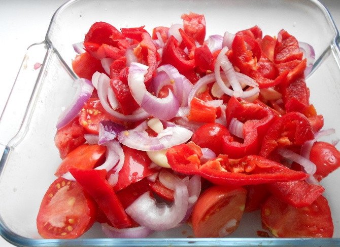 1. Этап. Суп с пампушками: Нарежьте помидоры, лук и перец. Уложите их в огнеупорную форму. Сверху присыпьте измельчённым чесноком и солью. Добавьте масло и перемешайте.