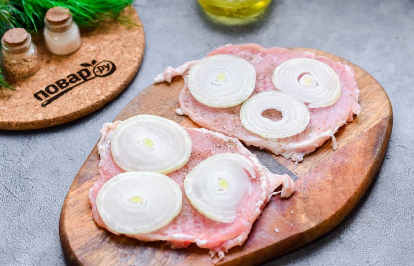 1. Этап. Мясо по-французски с горчичным соусом: Очистите лук и нарежьте его кольцами. Выложите лук поверх мяса.