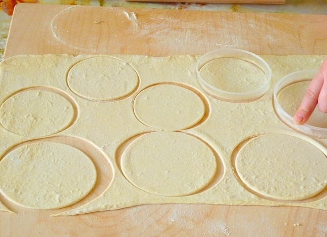 1. Этап. Бурятские бузы: Теперь достаньте тесто и раскатайте её в тонкий пласт около 4 мм толщиной. Чтобы тесто не липло к скалке и столу, можно его немного присыпать мукой. Из раскатанного теста нужно вырезать кружочки диаметром около 12 сантиметров. Для этого возьмите подходящую по диаметру кружку или другую форму.