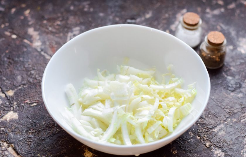 1. Этап. Салат Яркий праздник с курицей: Пекинскую капусту нарежьте мелко и переложите в салатник.