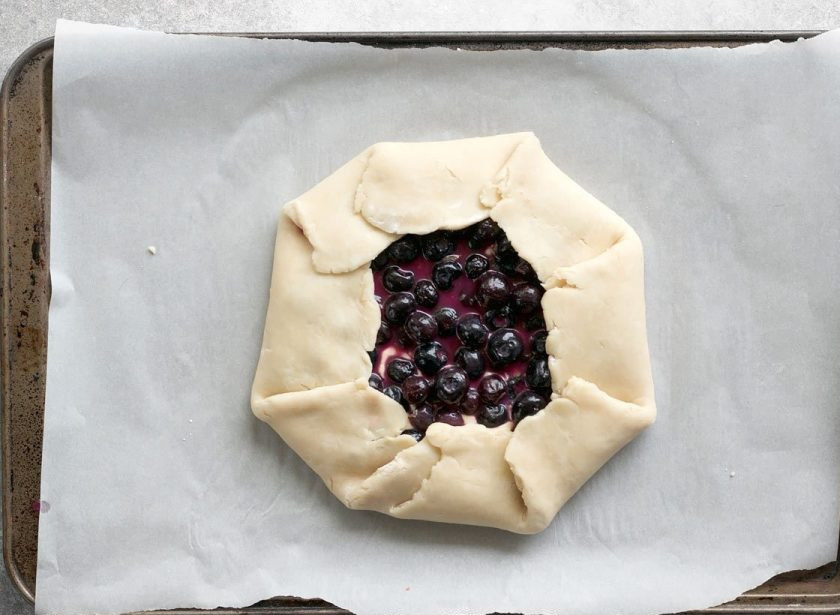 1. Этап. Галета с черникой и сливочным сыром: 9. Заверните к центру все края галеты и смажьте ее оставшимся куриным белком.