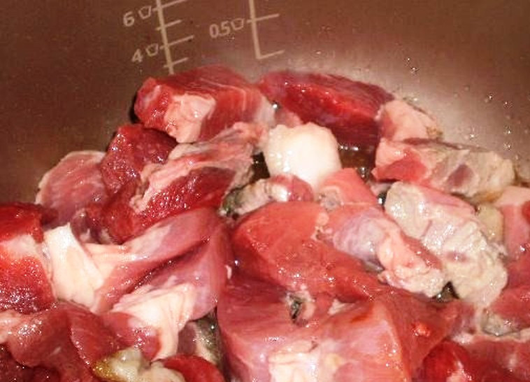 1. Этап. Вкусное мясо в мультиварке: Мясо помойте и нарежьте небольшими кусочками. Также нарежьте помидоры и измельчите чеснок.