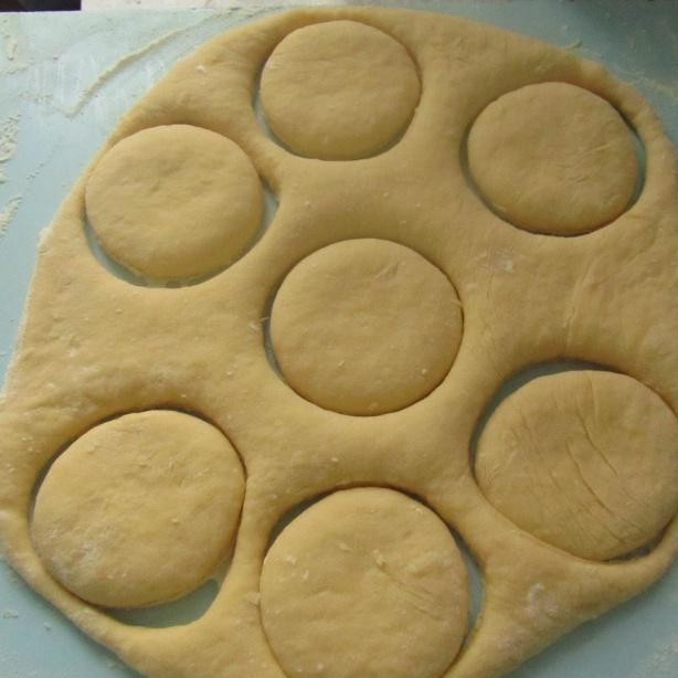 1. Этап. Пышки к Пасхе: Когда тесто поднимется, добавляем муку, пока не получится тесто, которое можно раскатать. Раскатываем тесто толщиной 1,5-2 см. С помощью стакана вырезаем круги, в середине делаем дырочки.