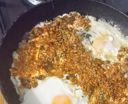 1. Этап. Яйца в шпинатовом креме с семенами: Выложить семена в остром соусе на яичную смесь.