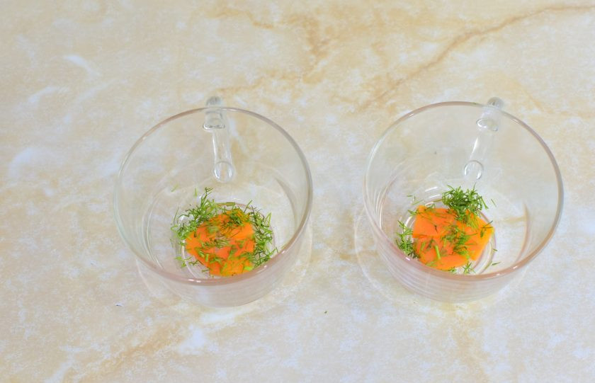 1. Этап. Заливное из курицы: В выбранную посуду выложите кусочки моркови и зелень.