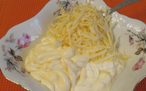 1. Этап. Красная рыба под соусом: Приготовим соус к рыбе. Смешиваем сметану, майонез и половину тертого сыра.