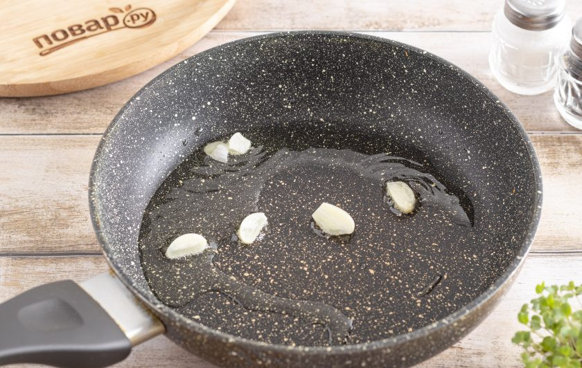 1. Этап. Рис жареный на сковороде: Разогрейте растительное масло в сковороде и добавьте в него пару очищенных и порезанных зубчиков чеснока. Жарьте около минуты до золотистого цвета, затем уберите чеснок из сковороды.