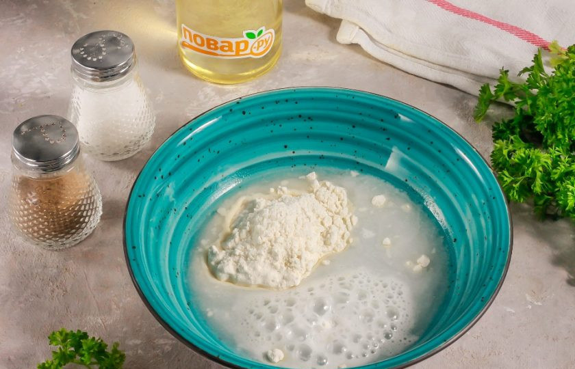 1. Этап. Пышный омлет на сковороде без молока: В отдельную емкость всыпьте пшеничную муку высшего сорта, разрыхлитель и влейте холодную воду.