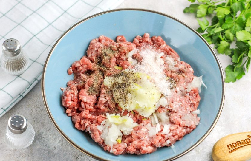 1. Этап. Пельмени Малороссийские из гречневой муки: В фарш натрите очищенную и промытую половинку репчатого лука и добавьте соль, молотый черный перец. По желанию допустимо всыпать и другие пряности, специи. Тщательно вымешайте фарш.