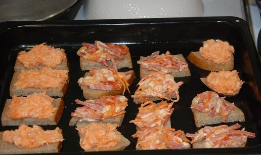 1. Этап. Мини бутерброды Ассорти: Противень смазываем растительным маслом. Часть кусочков хлеба смазываем намазкой 1, другую намазкой 2. Выкладываем на противень и отправляем в духовку на 15 минут