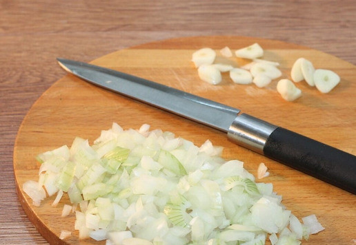 1. Этап. Картофельные лепешки с мясным припеком: 7. Вторую луковицу нарезаем маленькими кубиками, чеснок - дольками.