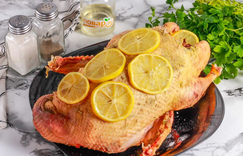 1. Этап. Утка с лимоном и розмарином в духовке: Лимон нарежьте кружочками, соком смажьте тушку, выложите нарезку на тушку и внутрь нее. Присыпьте сушеным розмарином внутри и снаружи. Оставьте для маринования на 1 час.