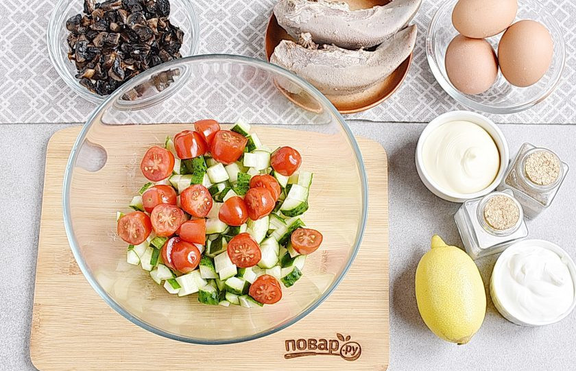 1. Этап. Салат Гурман с языком: Свежие огурцы нарежьте крупными кубиками, помидоры черри разрежьте пополам. Выложите в глубокую миску.