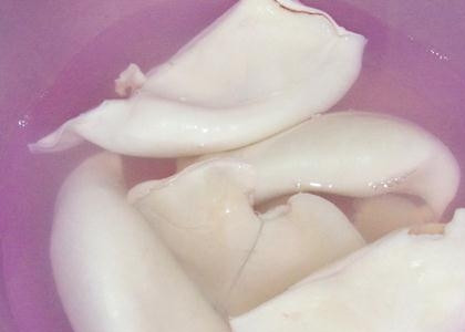 1. Этап. Салат из кальмаров и лука: 3. Возьмите термостойкую посуду. Сложите в нее кальмары, залейте их крутым кипятком. В большом количестве кипятка они мгновенно сварятся. Дайте возможность им остыть, не вынимая из воды.