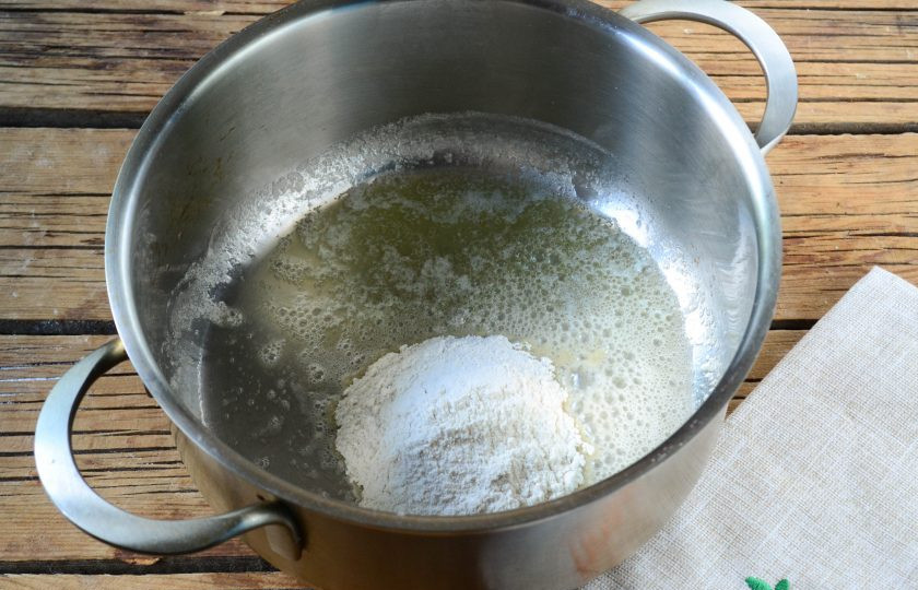 1. Этап. Гратен из картофеля в стиле маффинов: Начните с приготовления сливочного соуса. Для этого в небольшой толстодонной кастрюльке растопите сливочное масло. Добавьте к нему муку и энергичными движениями размешайте, чтобы мука полностью пропиталась маслом и заварилась.