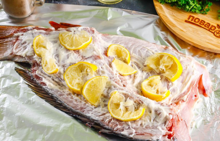 1. Этап. Сазан в духовке с лимоном: Нарежьте оставшуюся половину лимона ломтиками, из которой вы выдавили сок. Выложите сверху на рыбу. Разогрейте духовку до 200 градусов и поместите в нее противень на 30-40 минут.