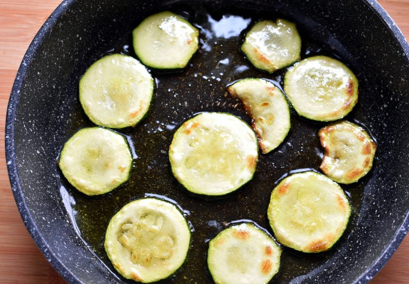 1. Этап. Острые пикантные цукини с овощами: Цукини нарежьте тонкими кружочками. Обжаривайте порциями на разогретом масле до легкой корочки. Выкладывайте на тарелку.