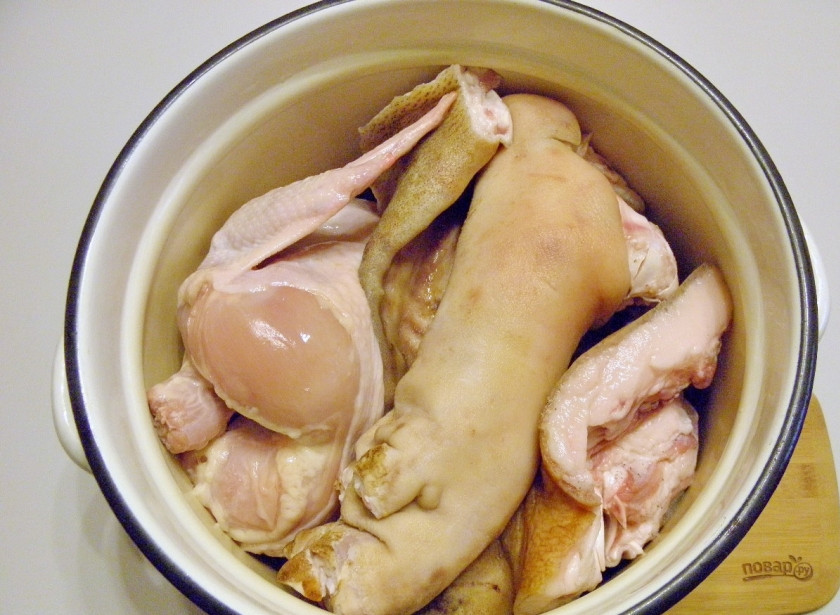 1. Этап. Холодец классический: Через час острым ножом почистите ножки и ушки от грязи и копоти. Отрубите топориком ногти. Ушки очень тщательно вымойте в складочках. Все должно быть идеально чистым. Курочку вымойте, удалите лишний жир и попку, остатки внутренностей, перья. Сложите все мясо в глубокую кастрюлю.