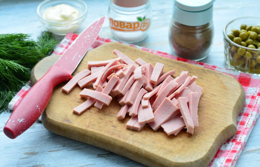 1. Этап. Слоеный салат из пекинской капусты: Нарежьте полосками вареную колбасу.