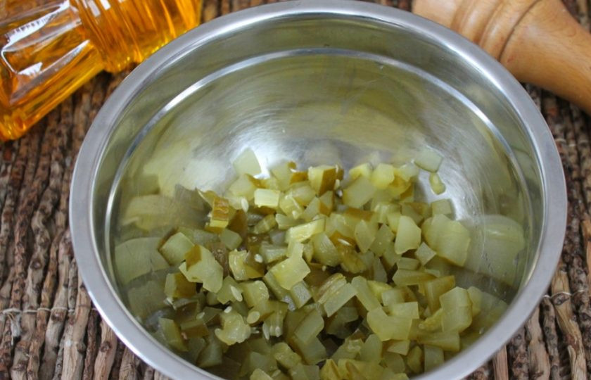 1. Этап. Винегрет с грибами и фасолью: Соленые огурцы режем кубиками и высыпаем в миску.