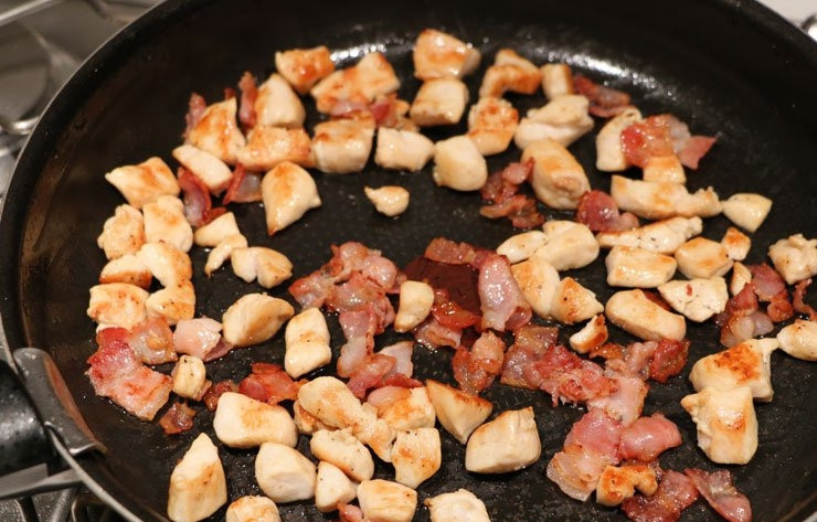 1. Этап. Тыква с мясом: Филе промойте и нарежьте вместе с беконом небольшим кубиком. На разогретой сковороде обжарьте бекон до золотистого цвета в течении 5-7 минут. Добавьте филе и готовьте еще 5 минут.